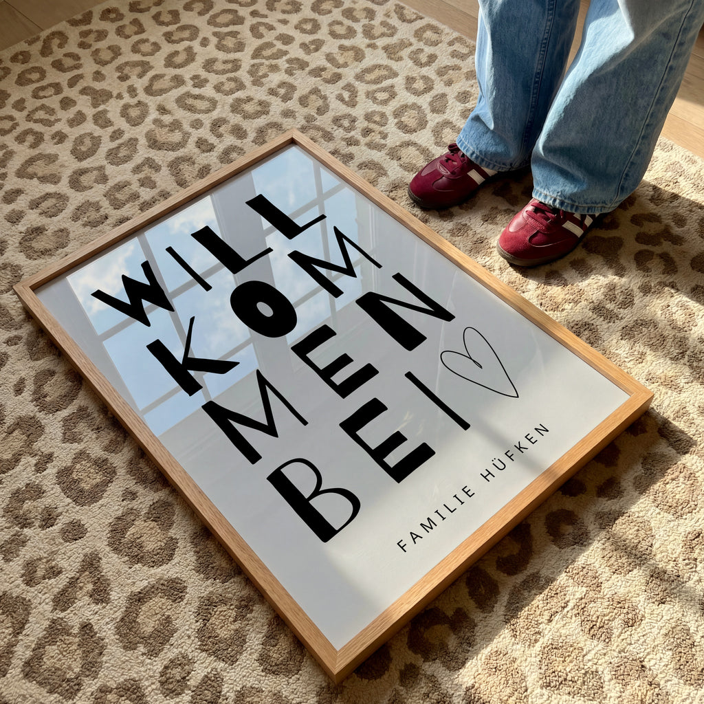 Minimalistisches Typografie-Poster mit dem Schriftzug „Willkommen bei“ in modernem, handgezeichnetem Stil, kombiniert mit personalisierbarem Familiennamen „Familie Müller“ und Zusatz „Since 2015“, stilvolle Wanddekoration für Eingangsbereich, Flur oder Wohnzimmer, modernes Familienposter mit persönlicher Note, schwarz-weißes Design mit klarer, zeitloser Ästhetik, dekoratives Willkommensschild für Zuhause, ideal als individuelle Wandkunst für Familien, personalisierbares Namensposter als Geschenk zur Hochzei