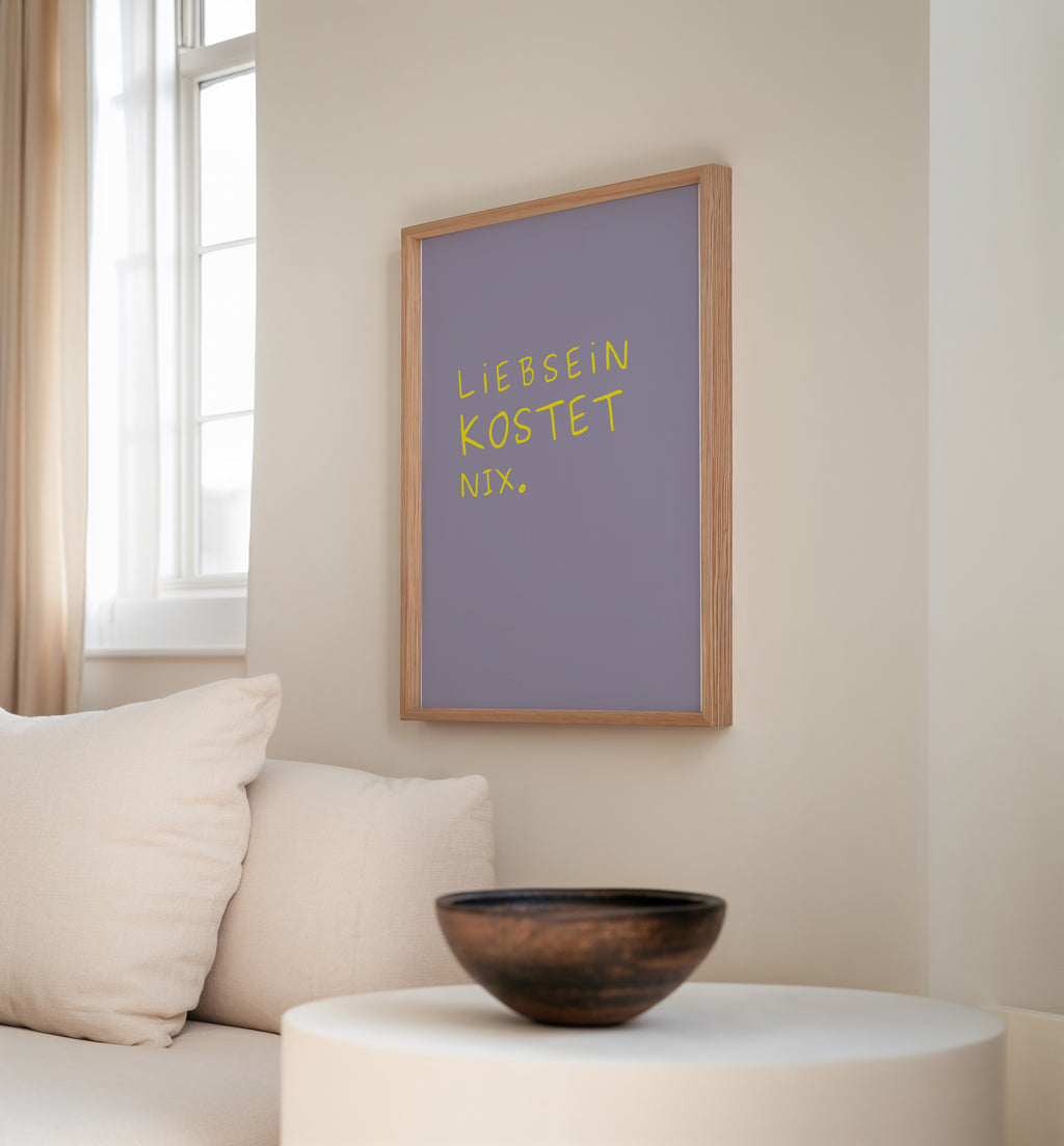 Minimalistisches Typografie Poster mit dem Spruch „Liebsein kostet nix“ in gelber Schrift auf lila Hintergrund
