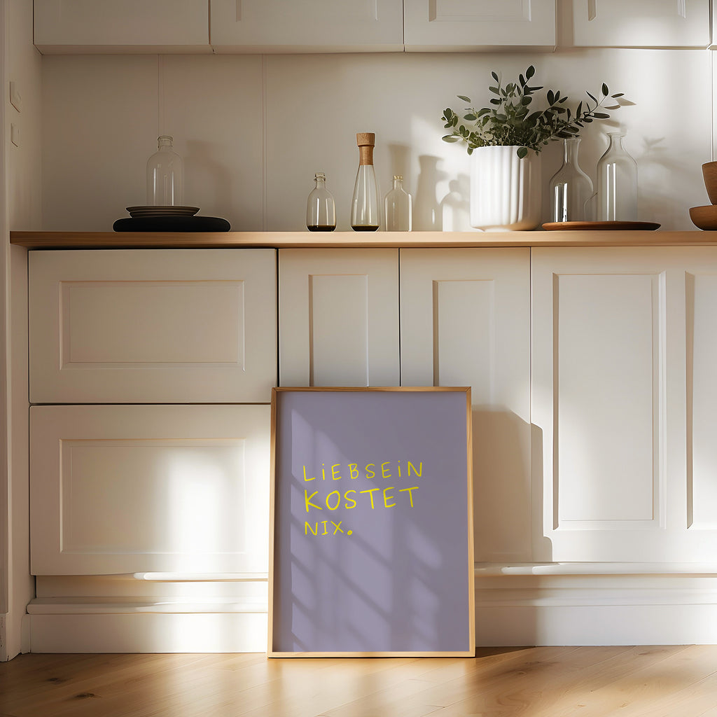 Minimalistisches Typografie Poster mit dem Spruch „Liebsein kostet nix“ in gelber Schrift auf lila Hintergrund