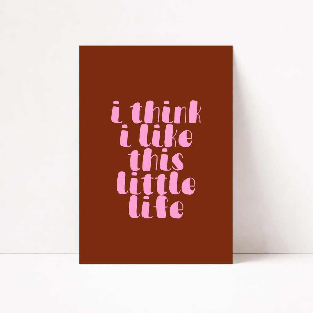 I Think I Like This Little Life Poster – Hol dir den Vibe von Selbstliebe, Ruhe und kleinen Glücksmomenten im Alltag. Die weiche, verspielte Typografie in zartem Rosa auf warmem Braunton wirkt modern, emotional und bringt eine cozy, positive Stimmung in dein Zuhause. Ob im Wohnzimmer, Schlafzimmer, Büro oder Flur – der Print sorgt sofort für eine warme, stilvolle Atmosphäre und wird zu einem dezenten Hingucker an jeder Wand.