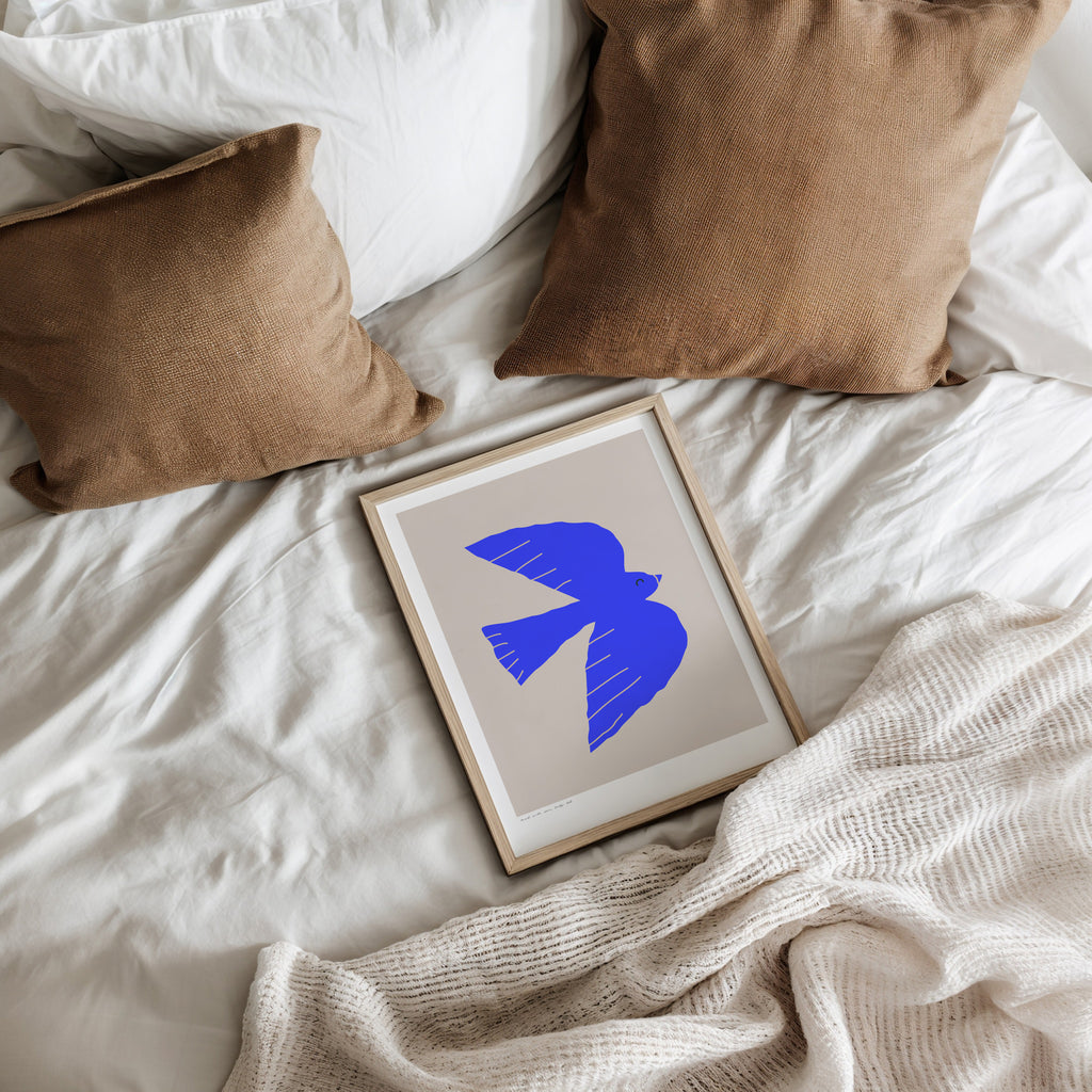 Modernes minimalistisches Poster mit abstrakter blauer Vogel-Silhouette auf hellem Hintergrund, grafisches Kunstwerk in kräftigem Ultramarin-Blau, stilisierte fliegende Taube als Symbol für Freiheit, Leichtigkeit und Natur, zeitgenössisches Wandbild im skandinavischen Design, ideal für Wohnzimmer, Schlafzimmer oder Büro, hochwertige Poster-Kunst für moderne Einrichtung, ästhetisches Grafikdesign mit klaren Formen und ruhiger Farbwirkung, dekoratives Wandposter für stilvolle Innenräume, minimalistische Kunst