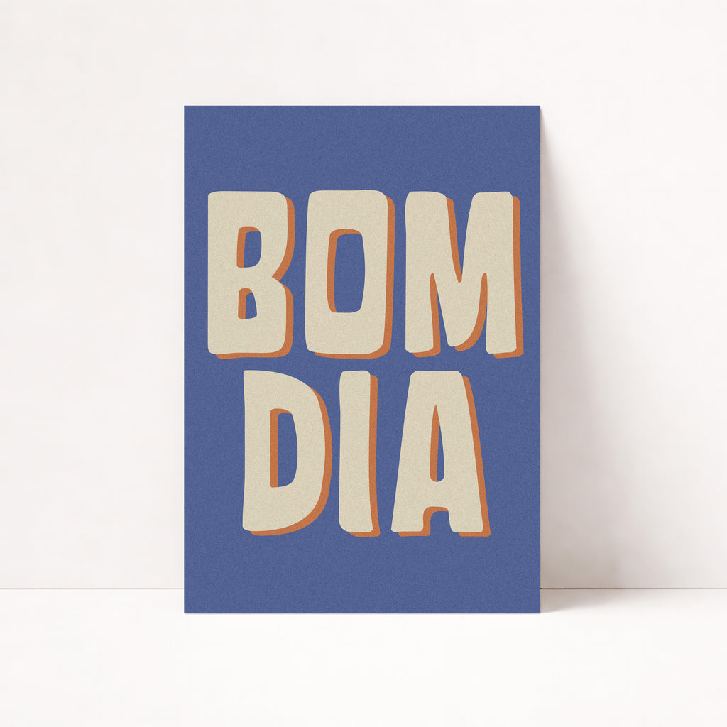 Bom Dia Poster im Retro-Stil mit beiger Typografie auf blauem Hintergrund in hellem Holzrahmen
